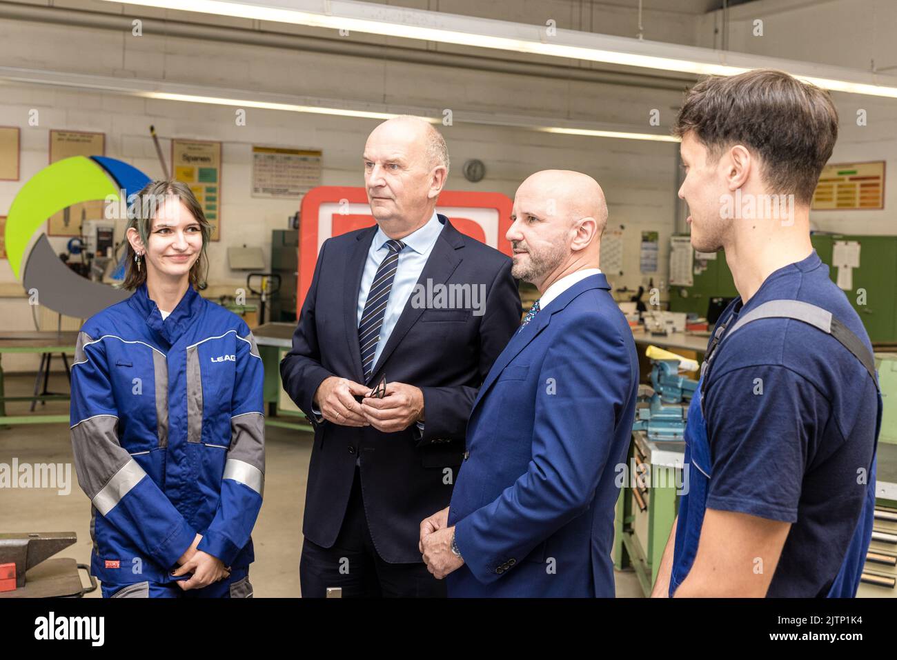 Peitz, Germany. 31st Aug, 2022. Together with LEAG apprentices Denise Gölitzer (L) and Lucian Roschek (R), Dietmar Woidke (2nd from left), Minister President of the State of Brandenburg, and Jörg Waniek, LEAG Chief Human Resources Officer, are in conversation. Waniek signed the training pact together with his colleague Seiler from Deutsche Bahn. Deutsche Bahn will take over the training workshop of the Lusatian energy company LEAG at the Jänschwalde power plant in the Spree-Neisse district from 2025 onwards Credit: Frank Hammerschmidt/dpa/Alamy Live News Stock Photo