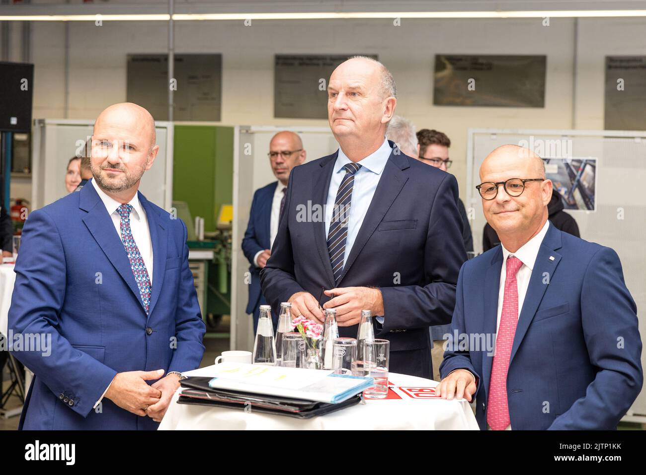 Peitz, Germany. 31st Aug, 2022. Jörg Waniek, (l-r) LEAG Chief Human Resources Officer, Dietmar Woidke, Minister President of the State of Brandenburg and Martin Seiler, Chief Human Resources Officer of Deutsche Bahn speak before the signing of the training pact between Deutsche Bahn and LEAG. Deutsche Bahn will take over the training workshop of the Lusatian energy company LEAG at the Jänschwalde power plant in the Spree-Neiße district from 2025. Credit: Frank Hammerschmidt/dpa/Alamy Live News Stock Photo
