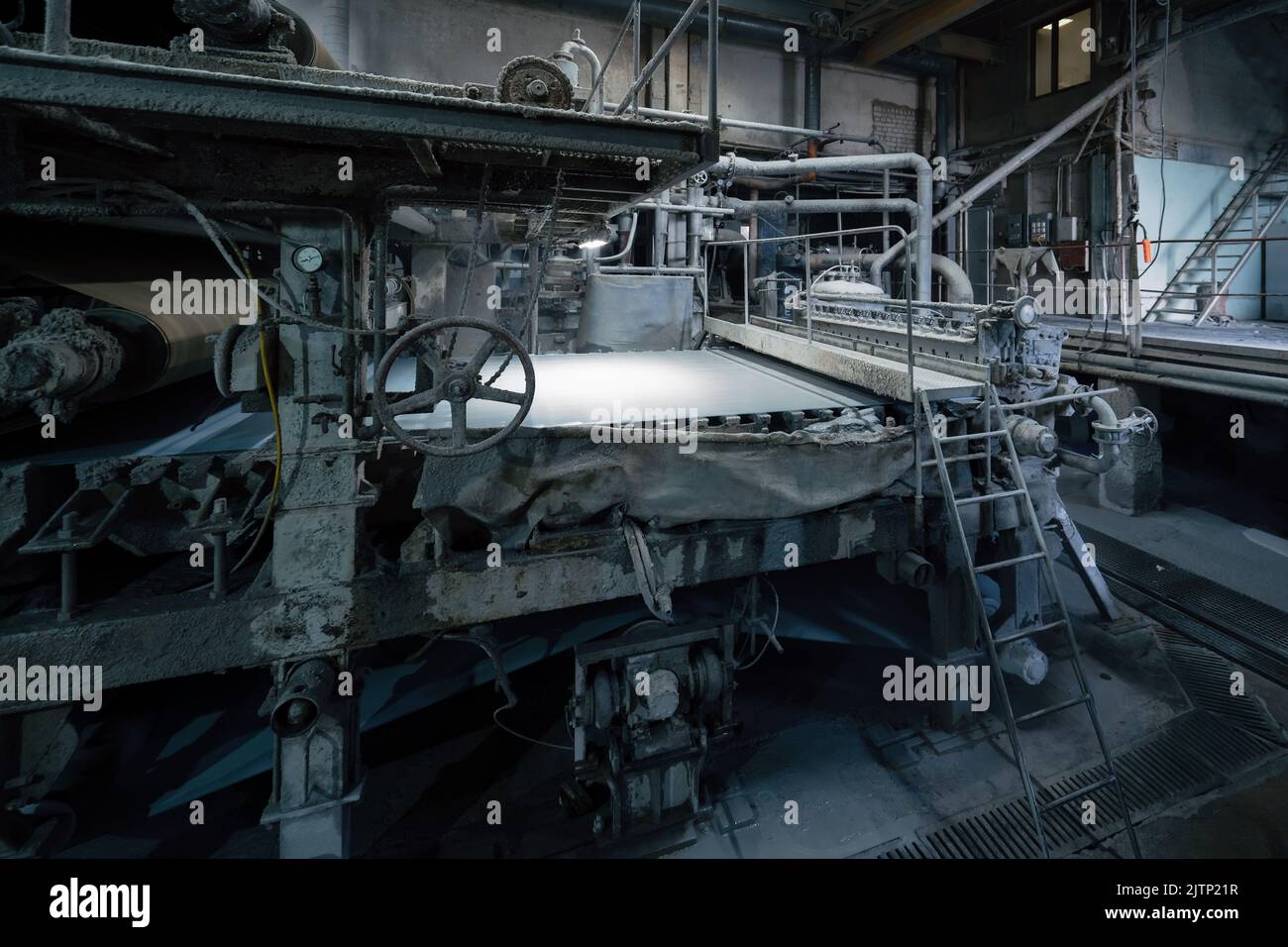 Production machine with rolls of new paper in waste paper recycling factory. Stock Photo