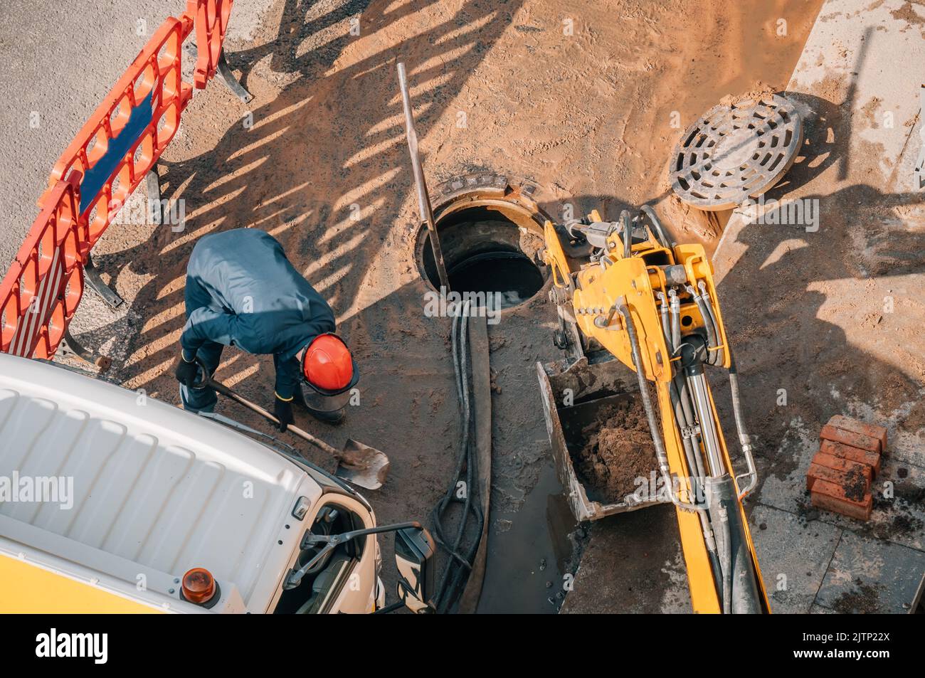 Worker carries out cleaning, repair and maintenance of outdoor street sewers. Stock Photo