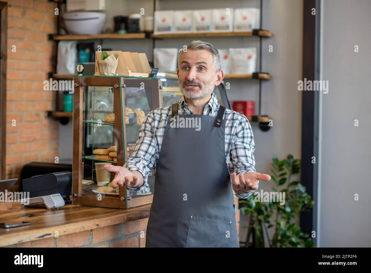Cafe owner welcoming customers in his establishment Stock Photo