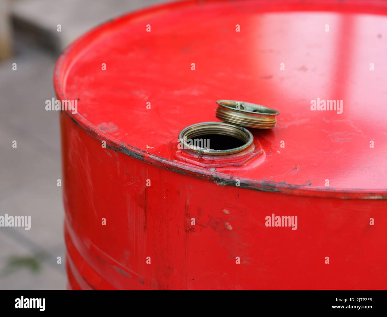 A closeup shot of the top part of a red barrel with the cap removed