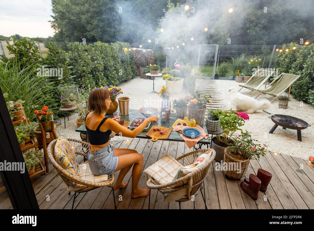 Woman having a dinner on terrace at backyard Stock Photo - Alamy