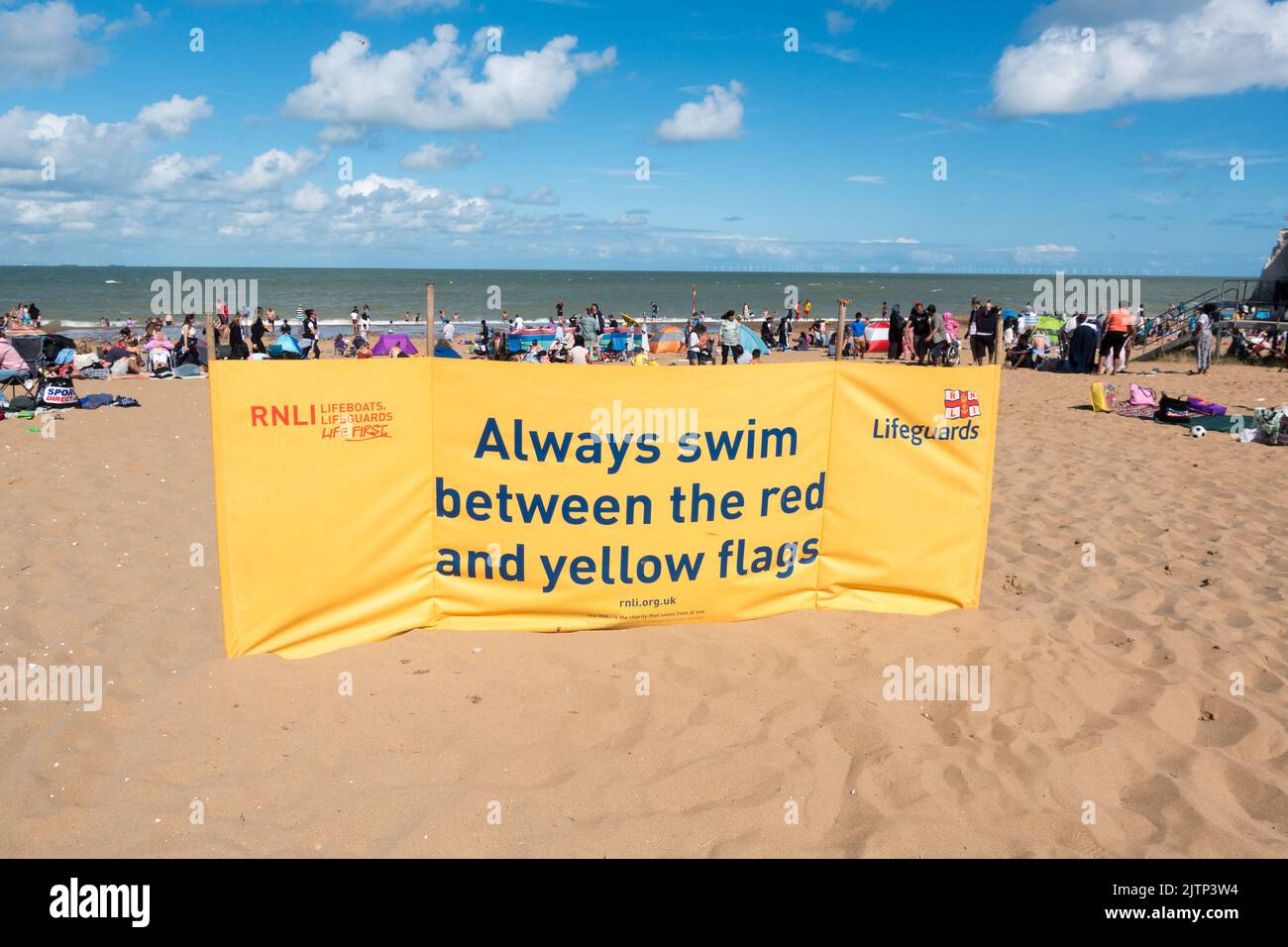RNLI yellow banner to swim between the flags where lifeguard watch is setup Stock Photo