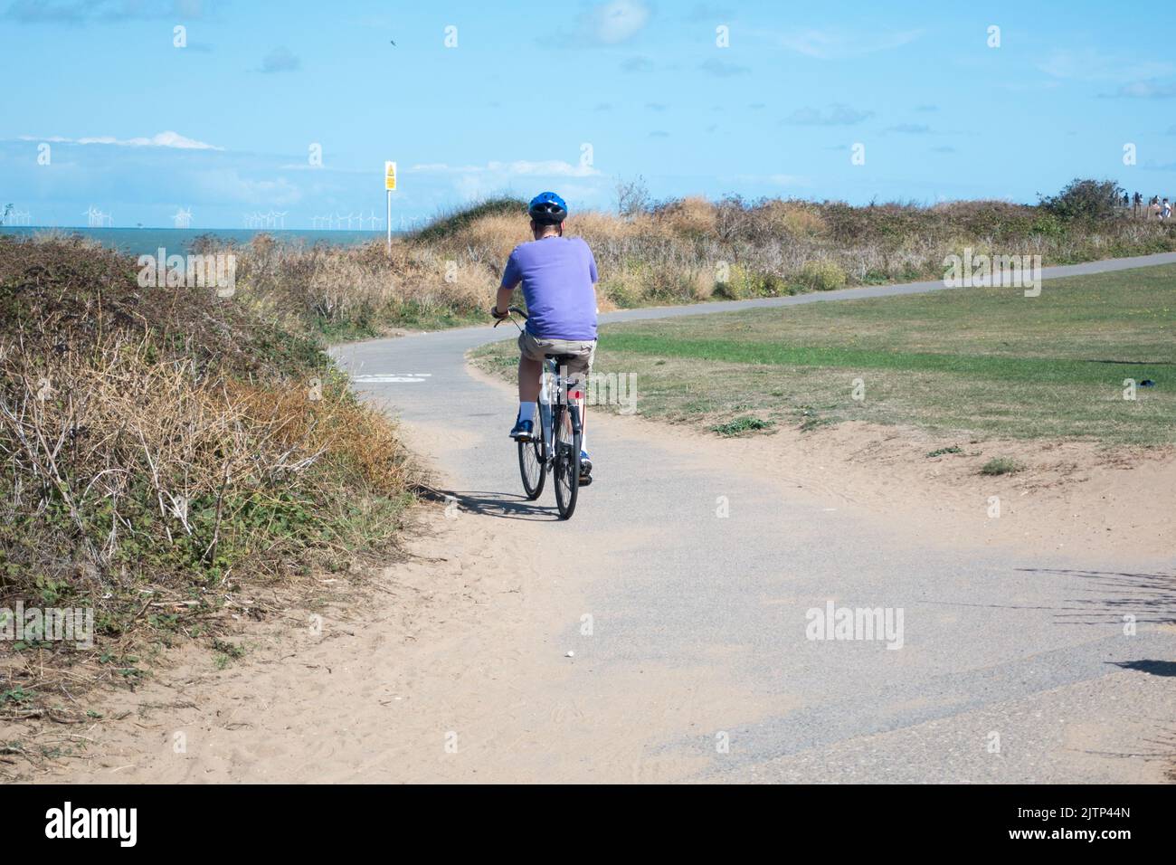 Adult male cycling on a hybrid bike along the Viking Coastal Trail kent seen near Botany Bay Stock Photo