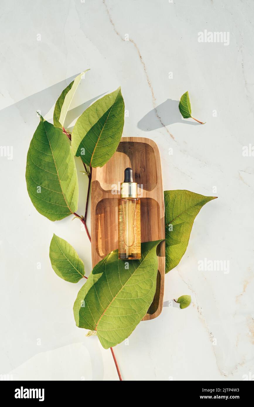 Natural serum golden with colloidal gold with leaves on a wooden tray