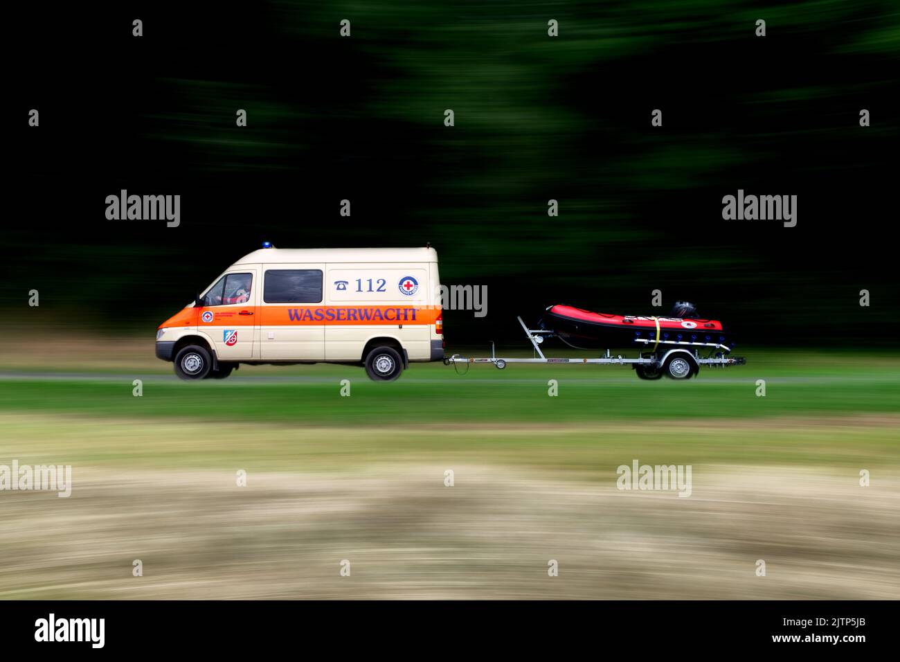 Water rescue emergency transporter driving with a boat trailer. Stock Photo