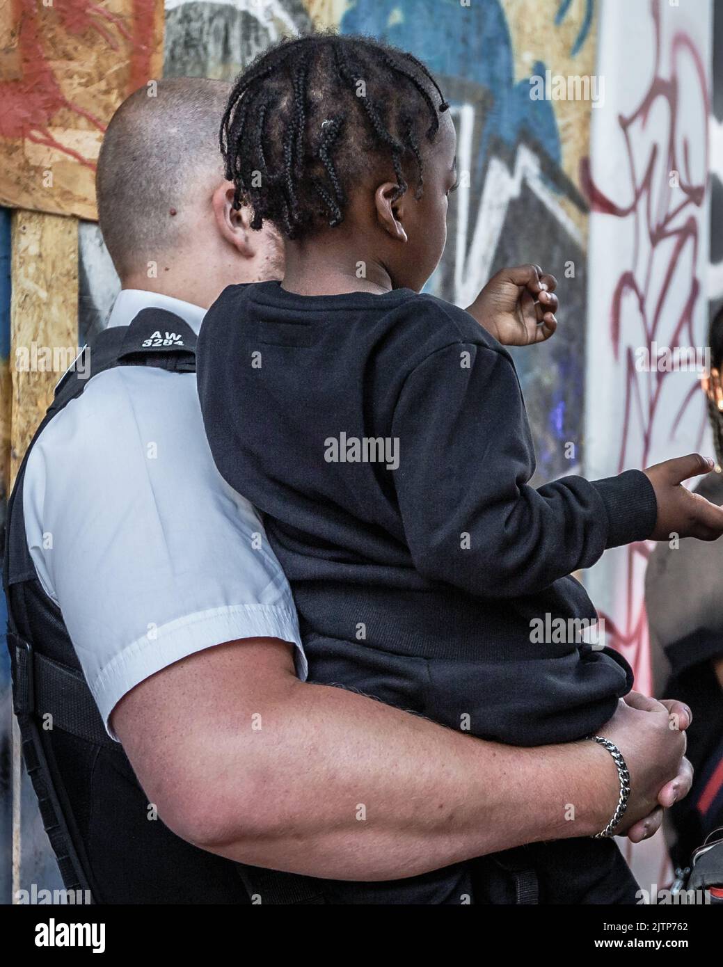 A police officer looks after a young child that has lost his parents at the Notting Hill Carnival. Stock Photo