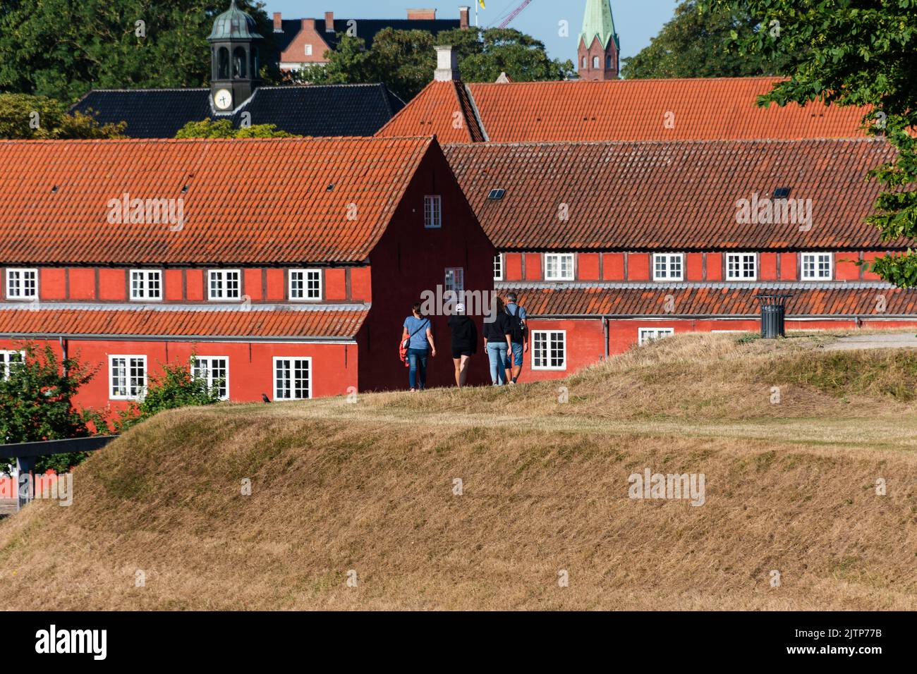 Copenhagen, Denmark. August 13, 2022.  People walking on top of the ramparts in Kastellet, with red barracks in the background Stock Photo