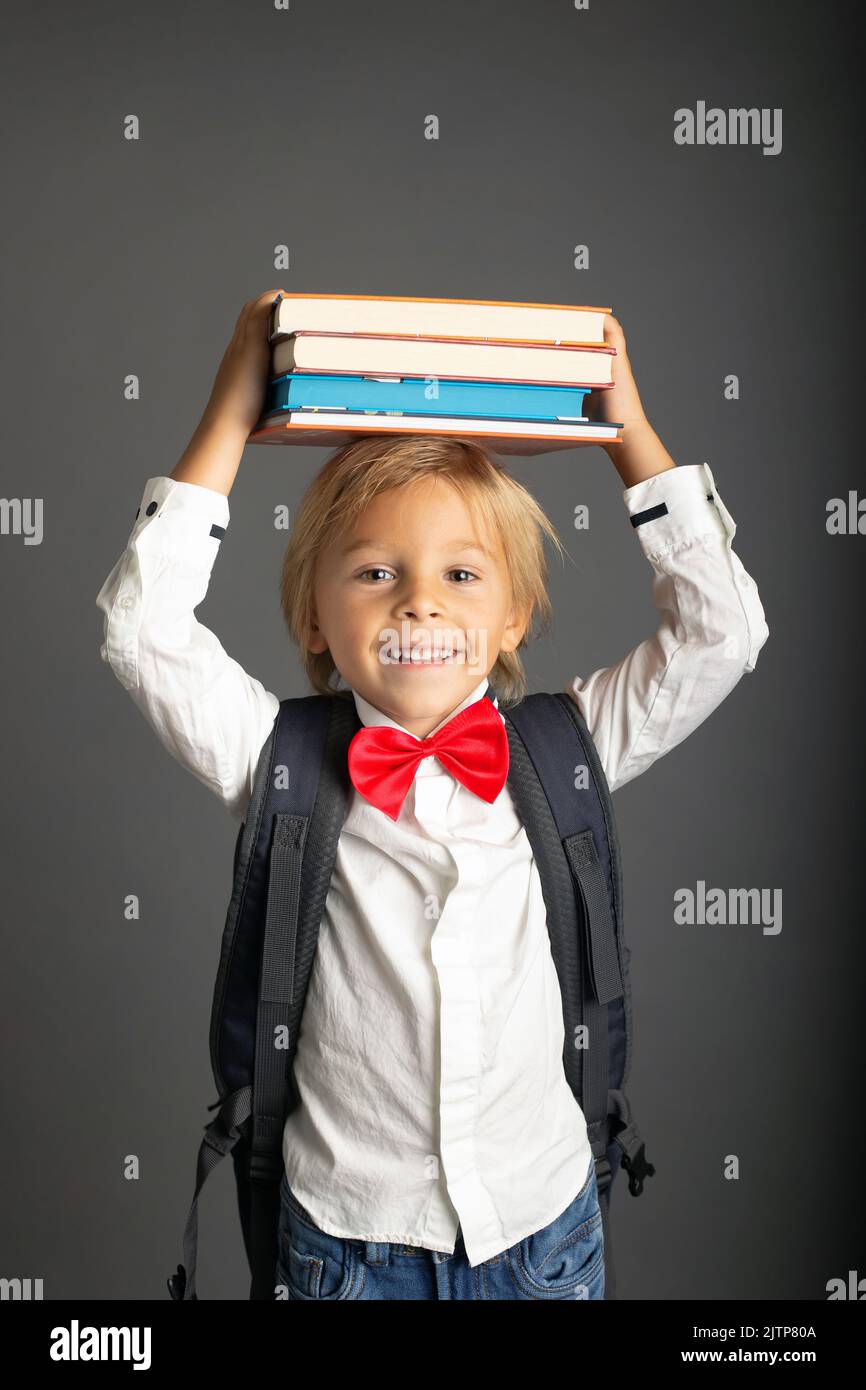 Cute preschool blond child, boy, holding books and notebook, apple ...