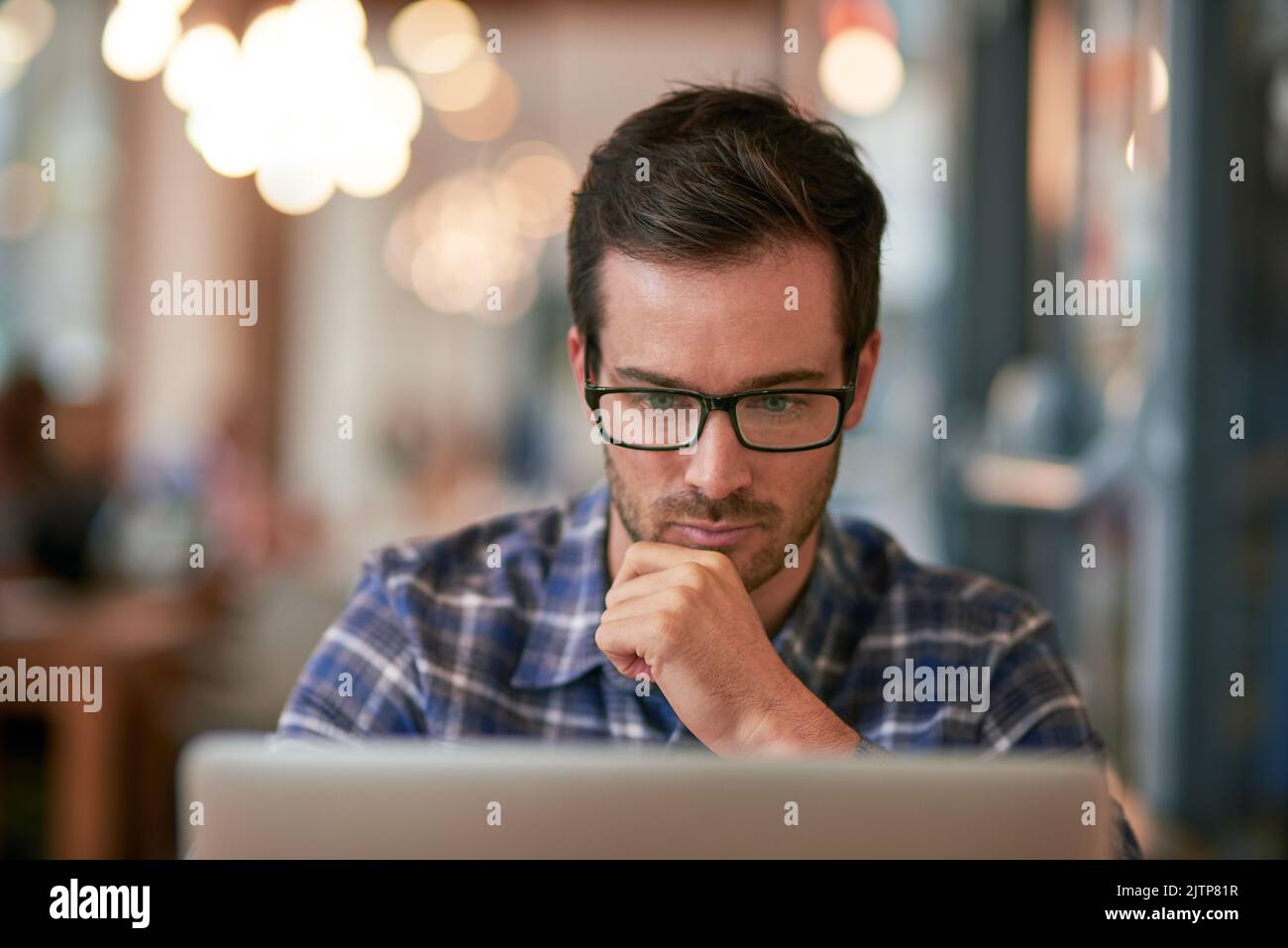 Do not disturb - unlimited browsing in process. a young man using his laptop while sitting in a coffee shop. Stock Photo