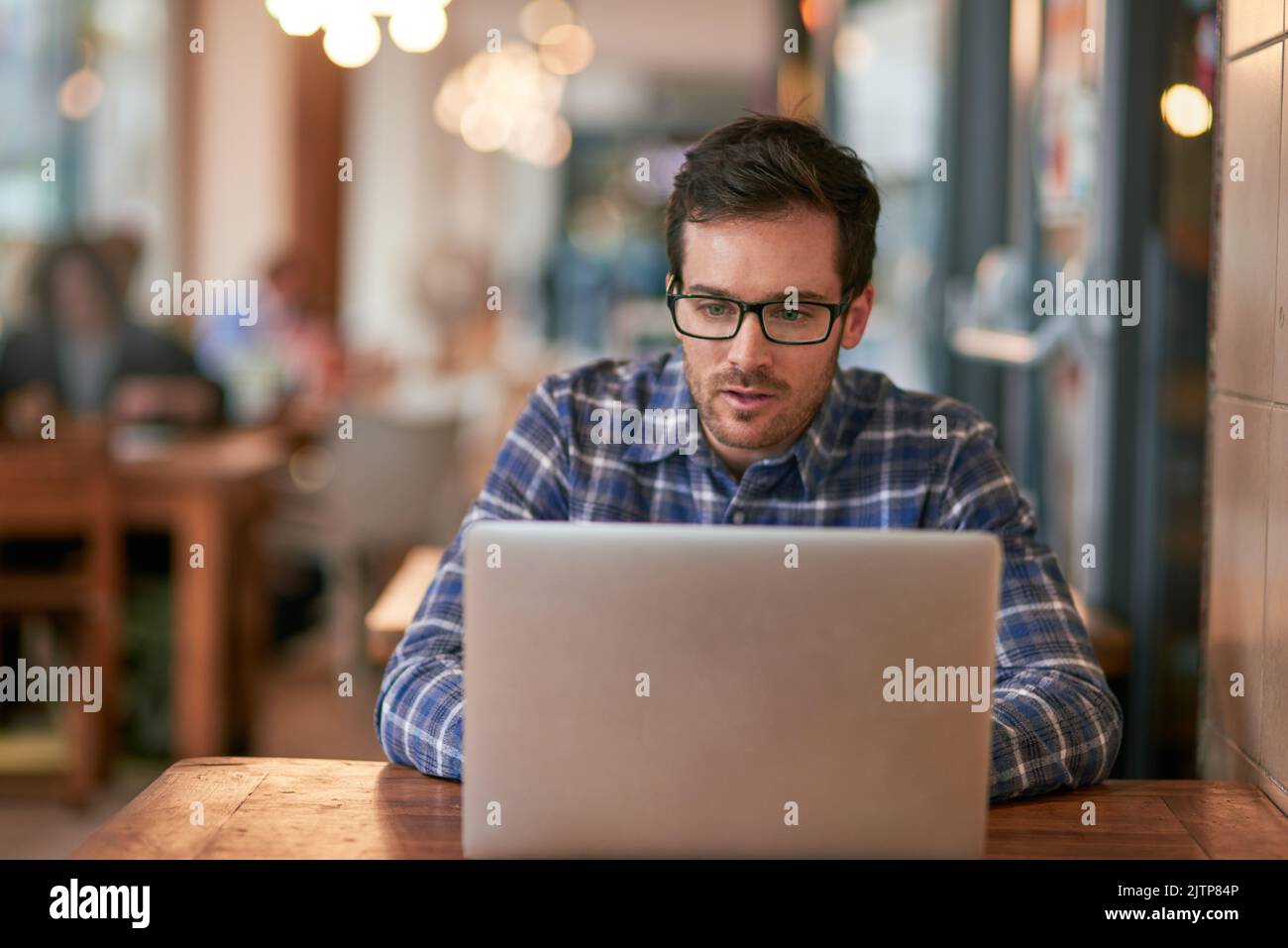 Freelancers work with floating desks. a young man using his laptop while sitting in a coffee shop. Stock Photo