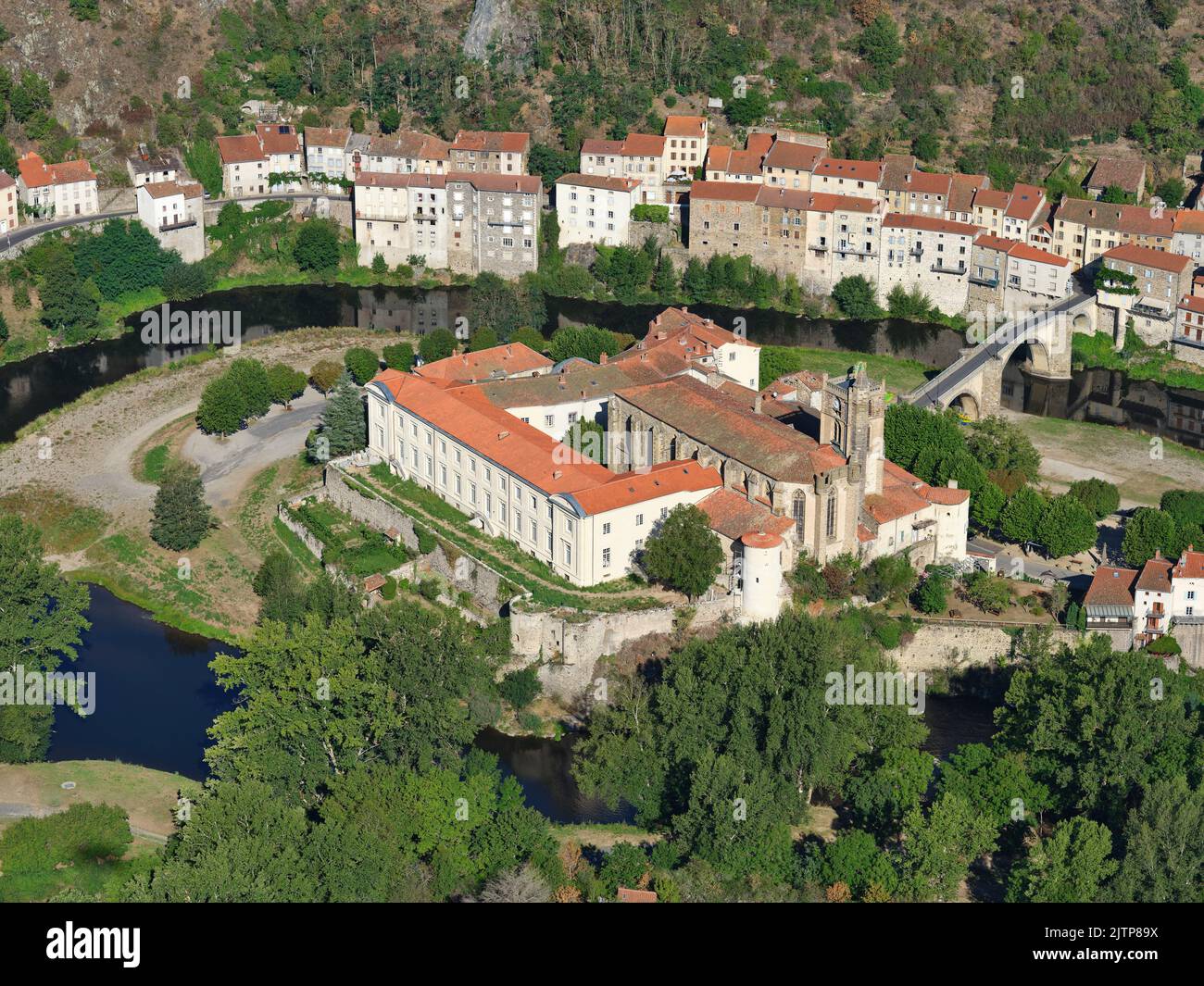 AERIAL VIEW. Priory of Sainte-Croix within a meander of the Allier River. Lavoûte-Chilhac, Haute-Loire, Auvergne-Rhône-Alpes, France. Stock Photo