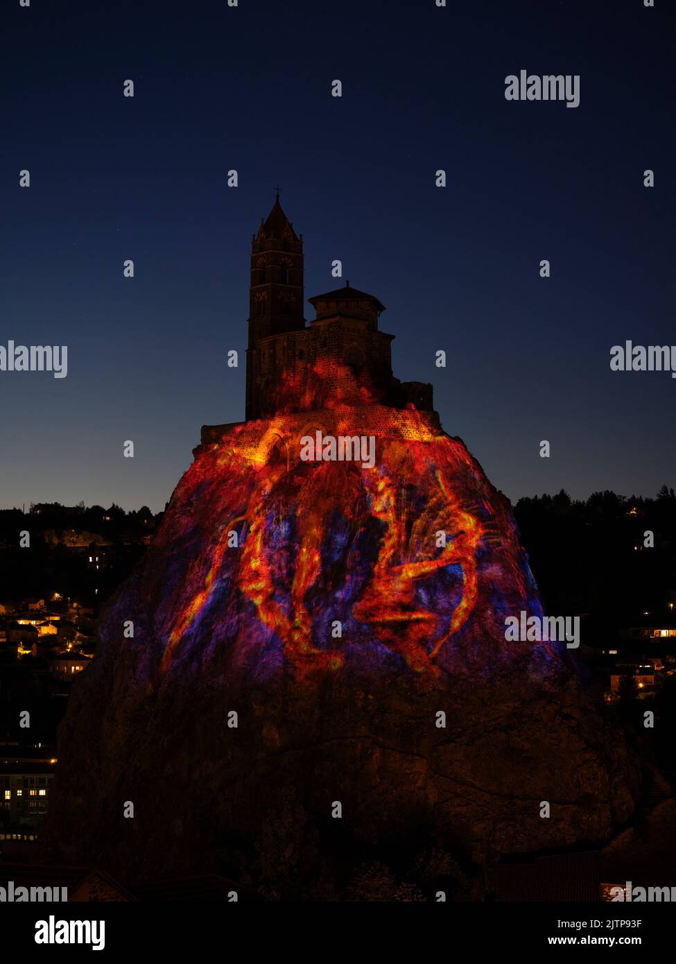 Light projection on a chapel perched on a volcanic neck. Aiguilhe, Haute-Loire, Auvergne-Rhône-Alpes, France. Stock Photo