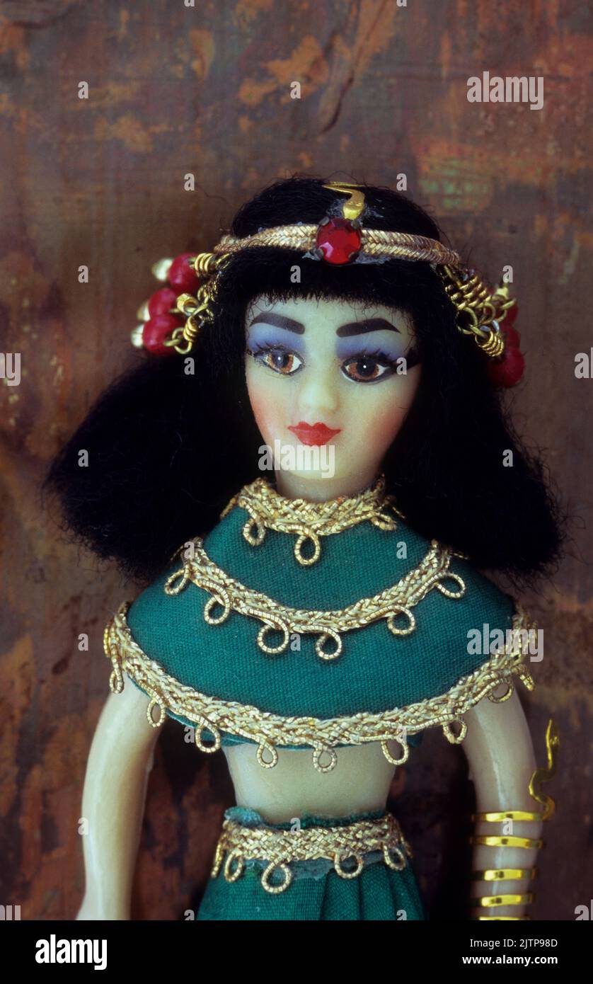 Upper half of doll of Cleopatra lying on tarnished copper Stock Photo