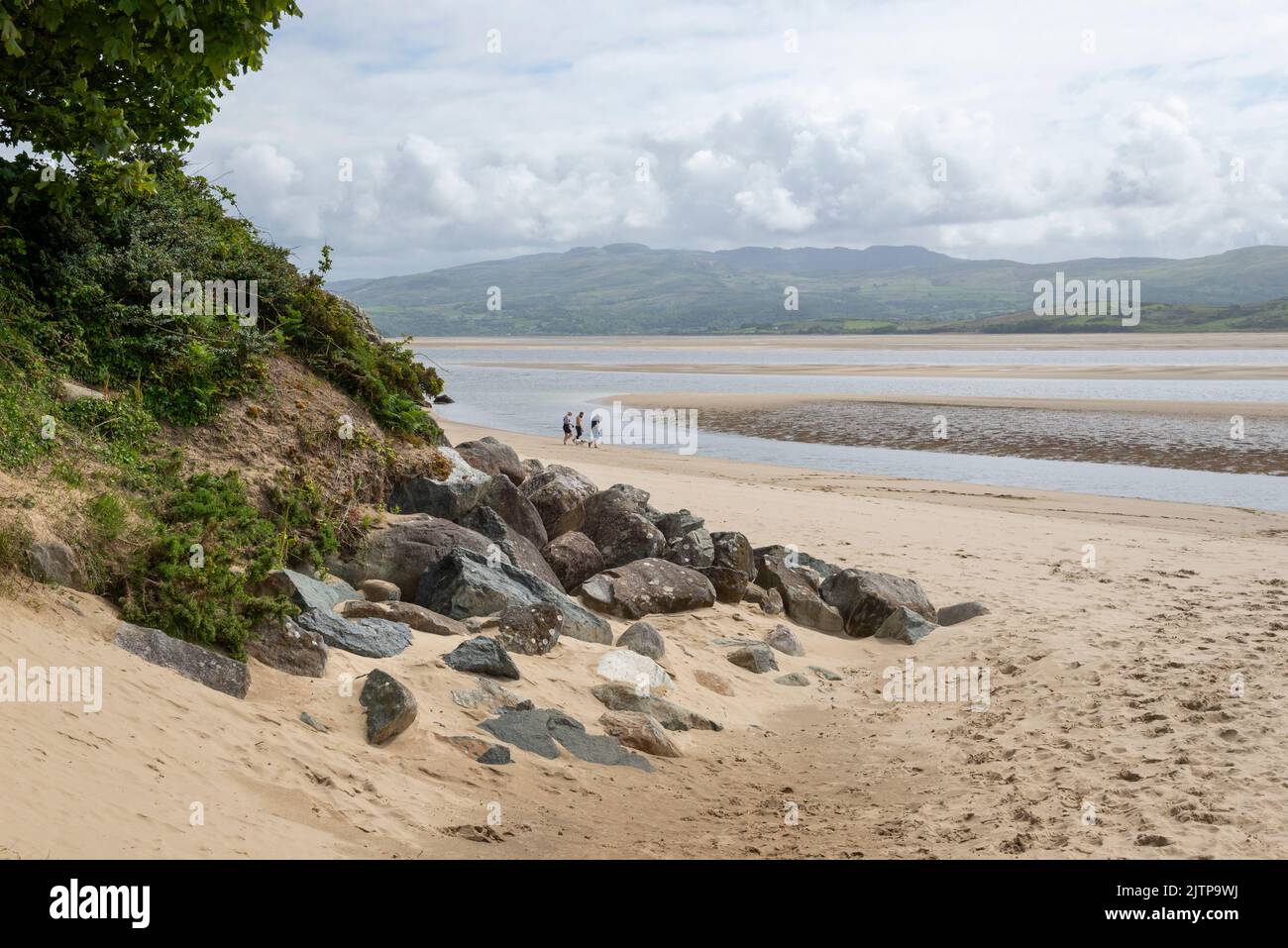 Walkers on the beach at Borth-y-Gest overlooking the Glaslyn estuary in North Wales. Stock Photo