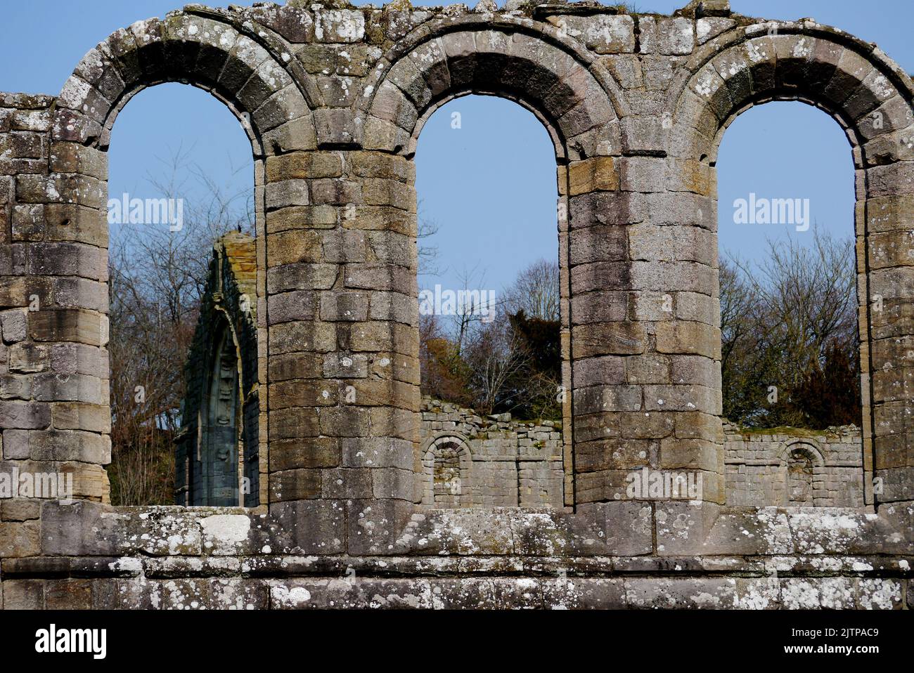 The Remains of Three Old Stone Arched Windows in the Ruins of Fountains Abbey Cistercian Monastery, North Yorkshire, England, UK. Stock Photo