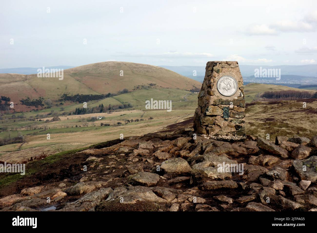 The Trig Pillar on the Summit of the Wainwright 'Gowbarrow Fell' with 'Little Mell Fell' Behind Lake in the Lake District National Park, Cumbria, UK. Stock Photo