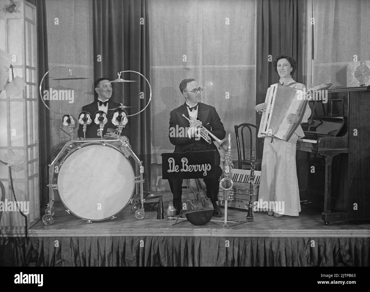 A British dance band, the De Berrys Trio, onstage at the Whitehall Court Hotel, London, England, UK in December 1937. Early dance and swing bands had their heyday in the UK during the 1920s–30s. Bands played in dance halls and hotel ballrooms. They played melodic, good-time music and individual players would play in several bands. This image is from an old glass negative – a vintage 1930s photograph. Stock Photo