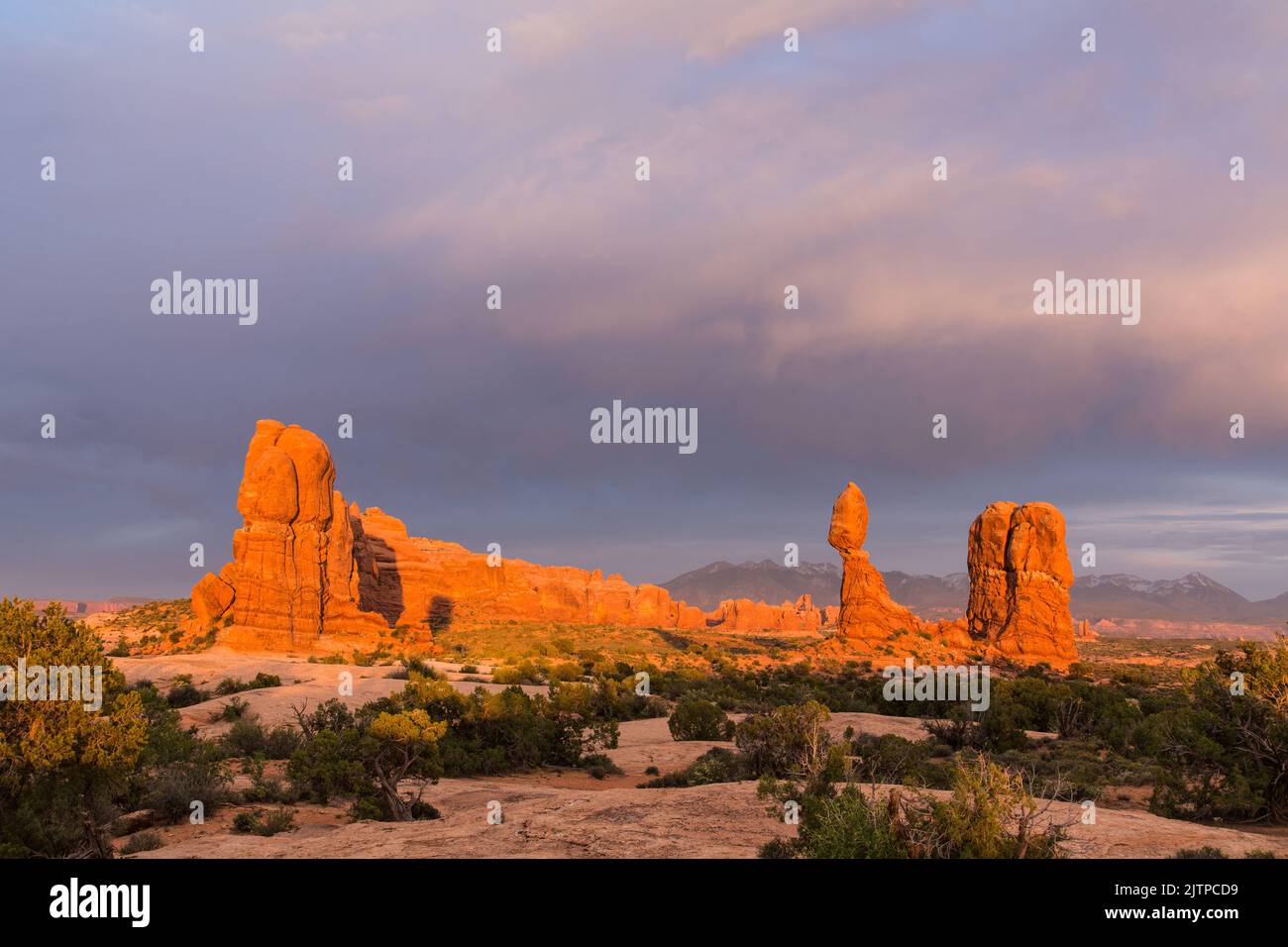 Sunset skies over Balanced Rock in Arches National Park near Moab, Utah.  In the background are the La Sal Mountains. Stock Photo