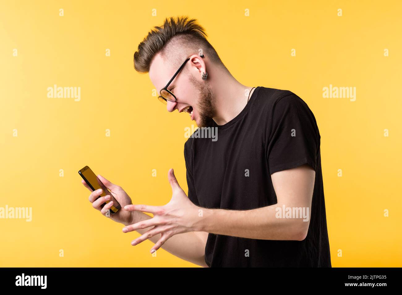 wtf young man screaming smartphone grimacing Stock Photo