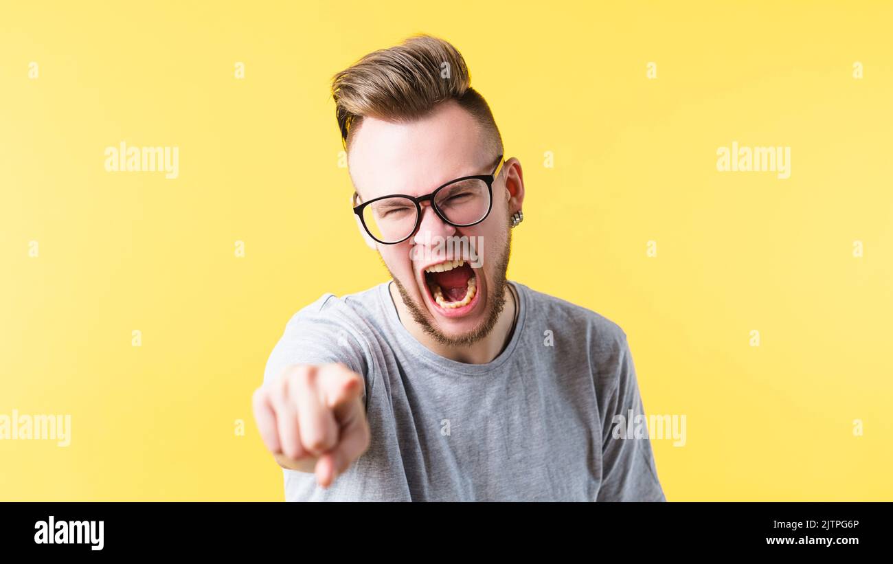 enraged man screaming pointing mouth open anger Stock Photo