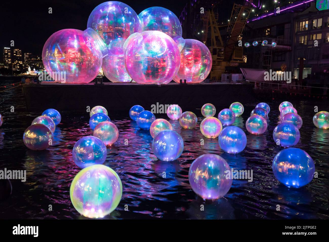 Ephemeral Oceanic, the coloured spheres installed at Walsh Bay below the Sydney Harbour Bridge for Vivid 2022 in Sydney, Australia Stock Photo