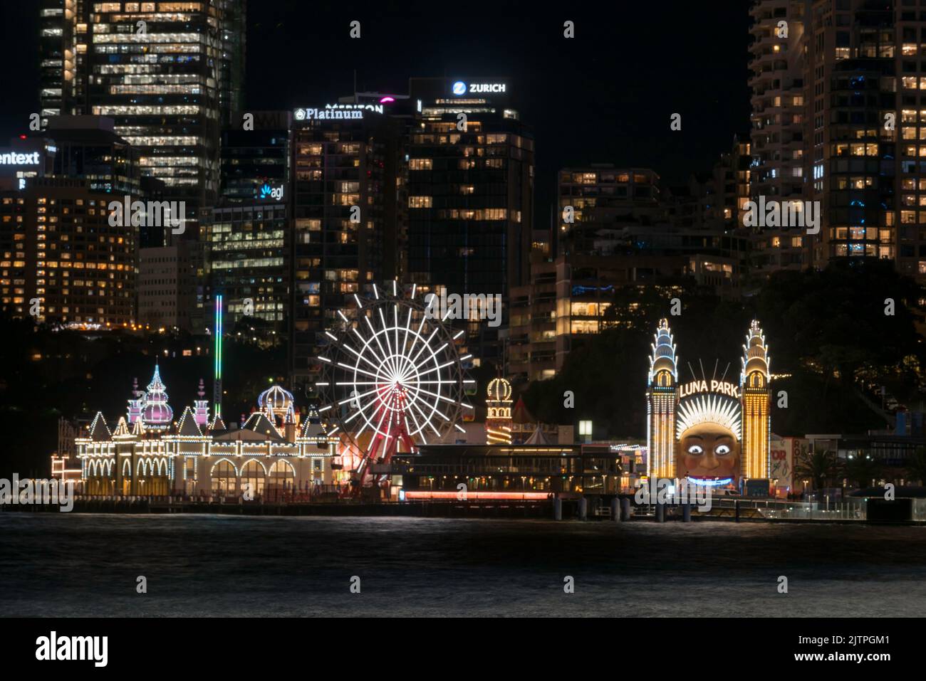 The scary smiling face, the Ferris wheel and the rest of Luna Park on the harbour foreshore in Sydney, lit up during Vivid Sydney 2022 in Australia Stock Photo