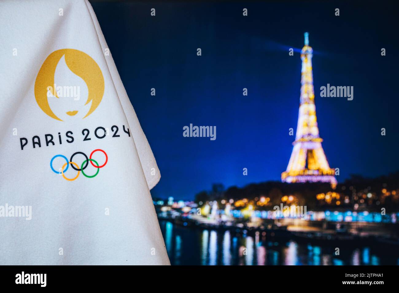 PARIS, FRANCE, AUGUST 8. 2022: Summer olympic game Paris 2024 black background. Official logo of SOG 2024 in Paris on white blanket with dark Eiffel T Stock Photo