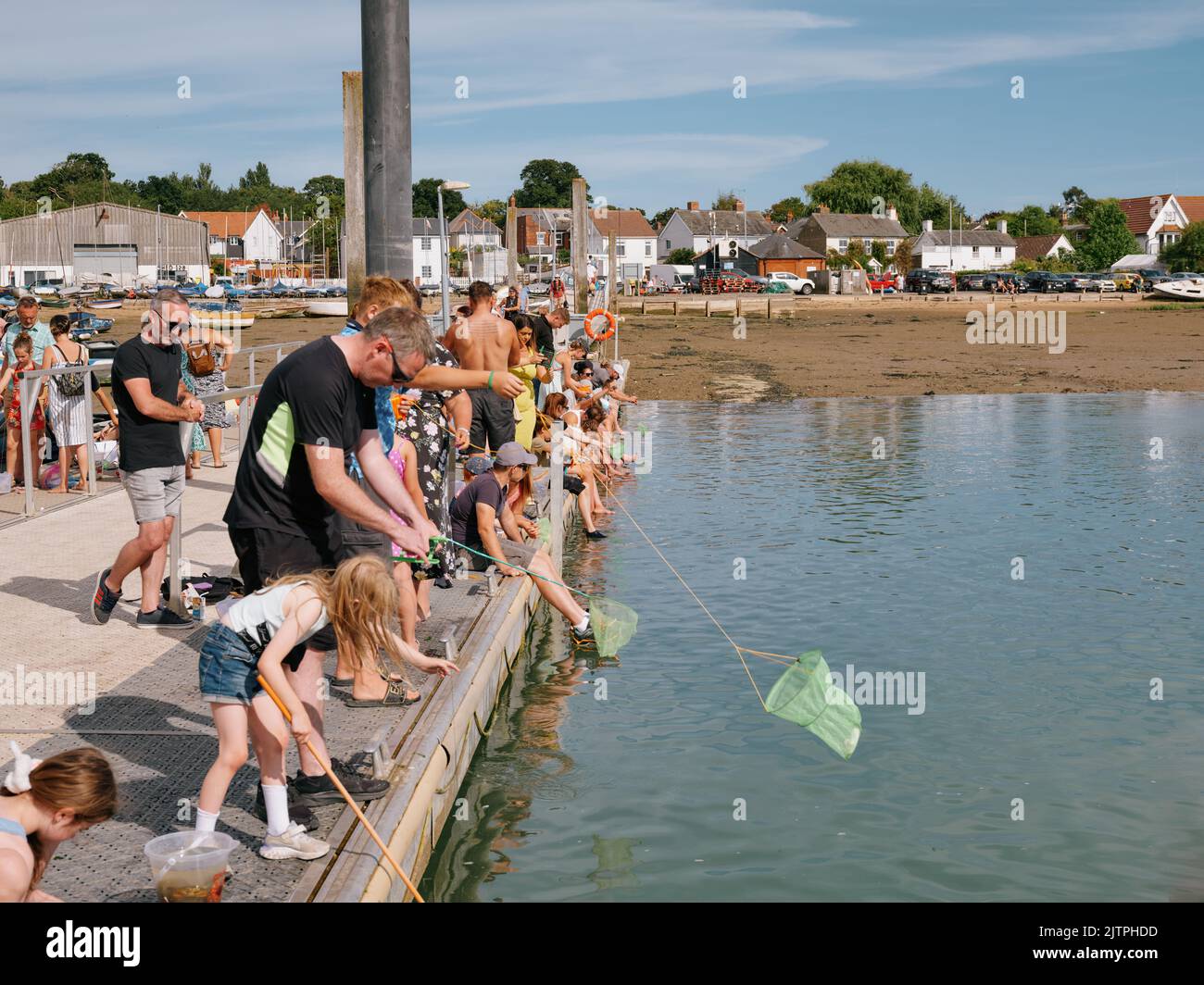 Summer tourist visitors crabbing on the floating pontoon at West Mersea