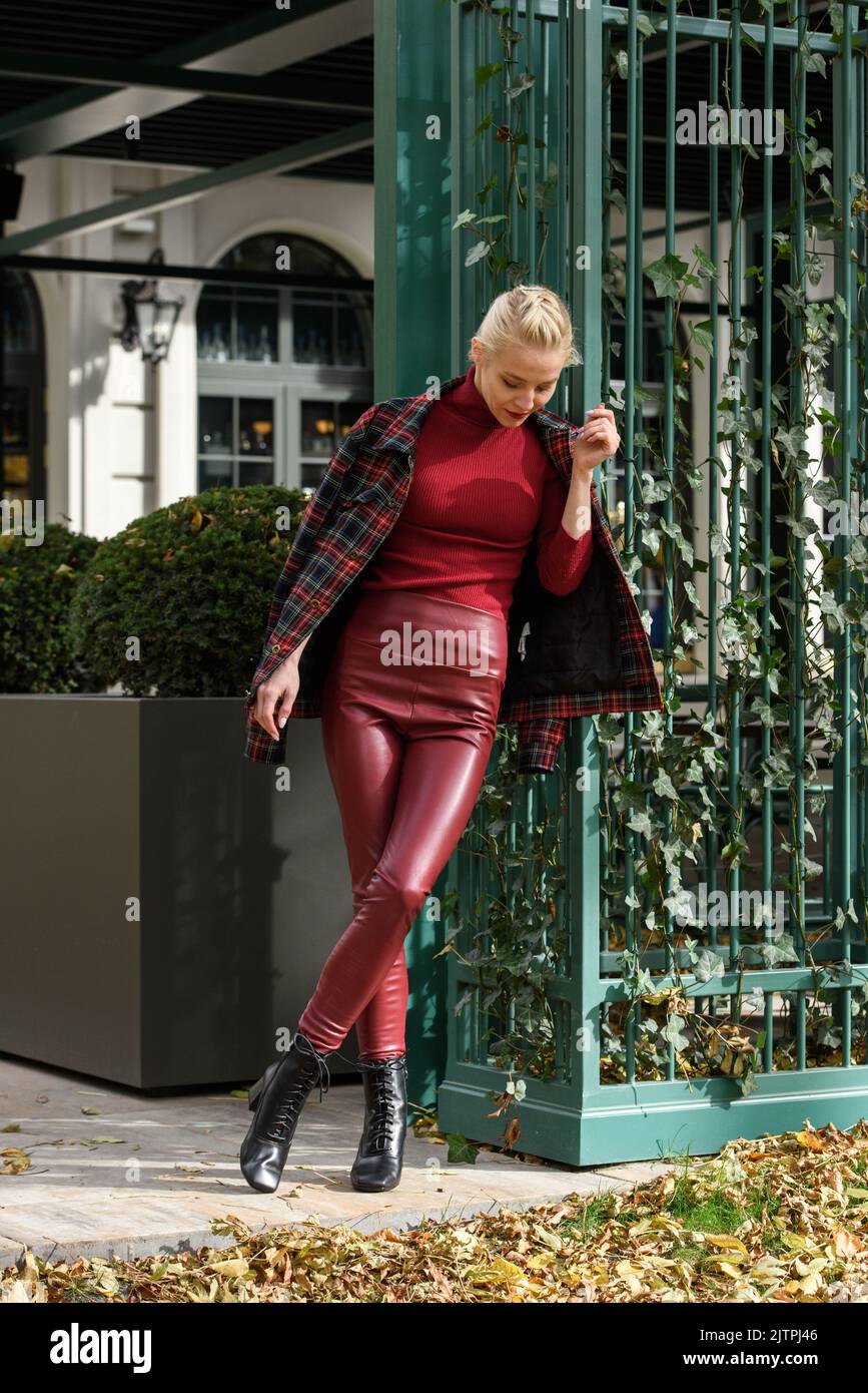 https://c8.alamy.com/comp/2JTPJ46/fashionable-blonde-girl-with-red-lipstick-posing-outdoors-dressed-in-a-red-leather-leggings-turtleneck-and-checkered-jacket-fit-figure-2JTPJ46.jpg