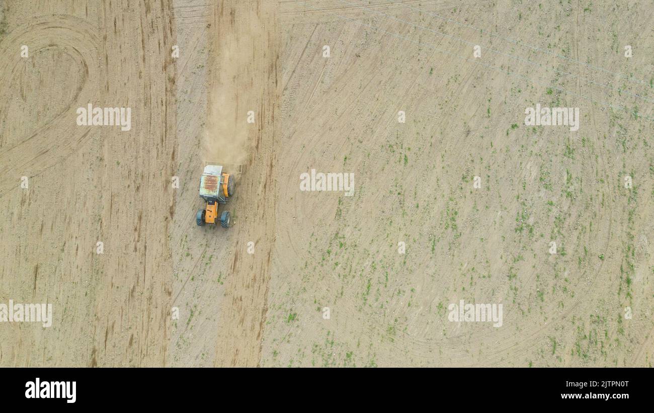 Farmer in a tractor in a dry dusty field. Stock Photo
