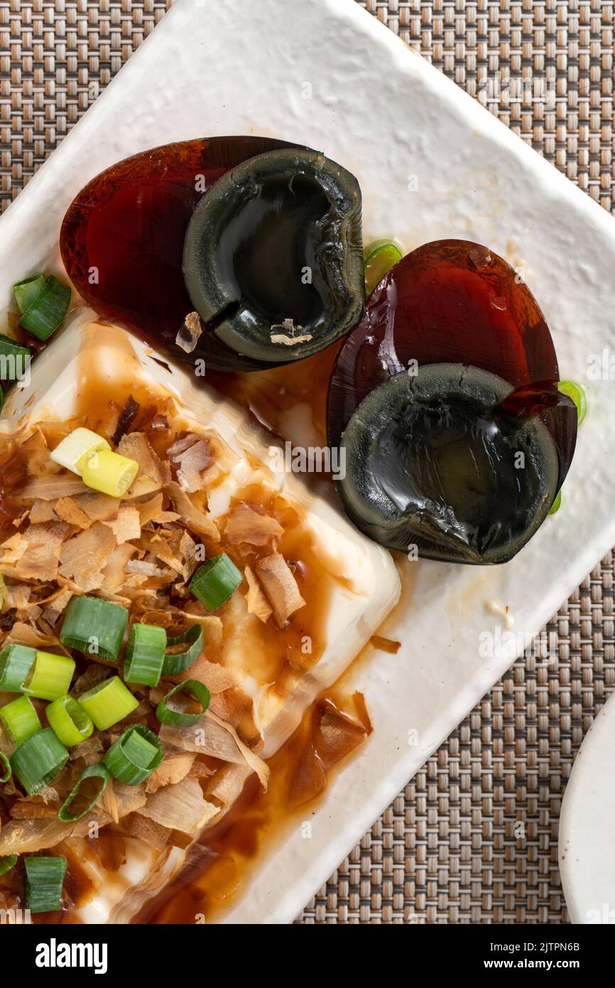 Delicious Chilled tofu and century egg food with soy sauce and bonito flakes topping in Taiwan. Stock Photo