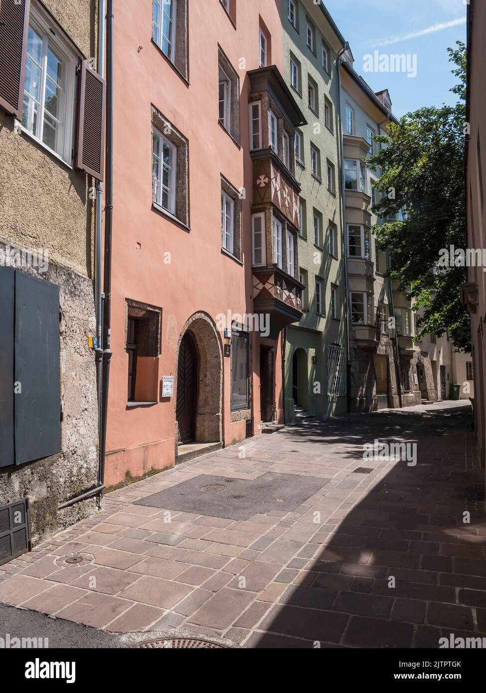 This street scene image is one of the many narrow alleyways in the old medieval city of Innsbruck, provincial capital city of Tirol in Austria. Stock Photo