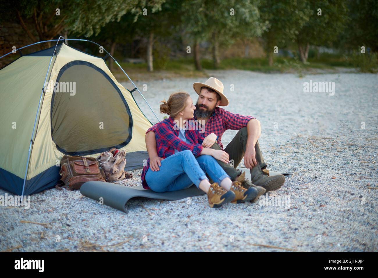 walk in nature. couple of lovers sit and talking in camping near tent