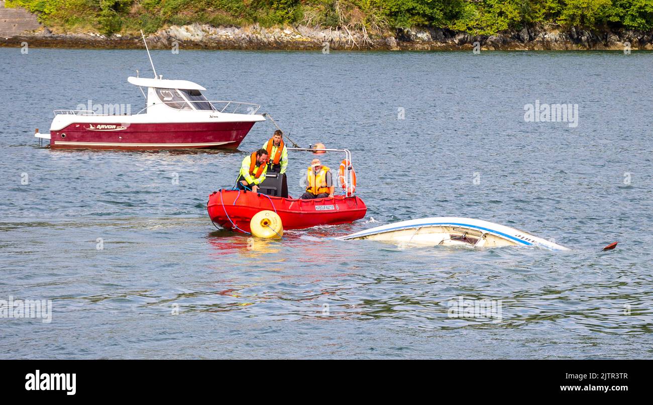 Local Harbour Master removing sunken yacht towing it away from mooring with Waly Boat Stock Photo