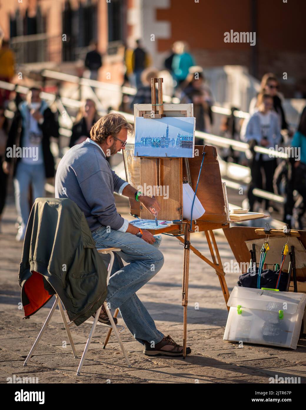 Venice, Italy - October 28, 2021: Artist painter on a street in Venice, sunny day in autumn Stock Photo