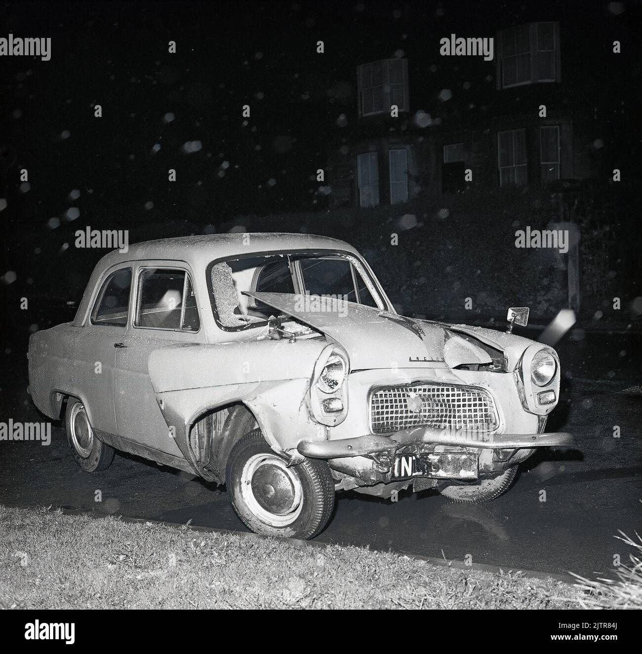 1960s, historical, night-time, a view of a crashed Ford Anglia 100E of the era. Stock Photo
