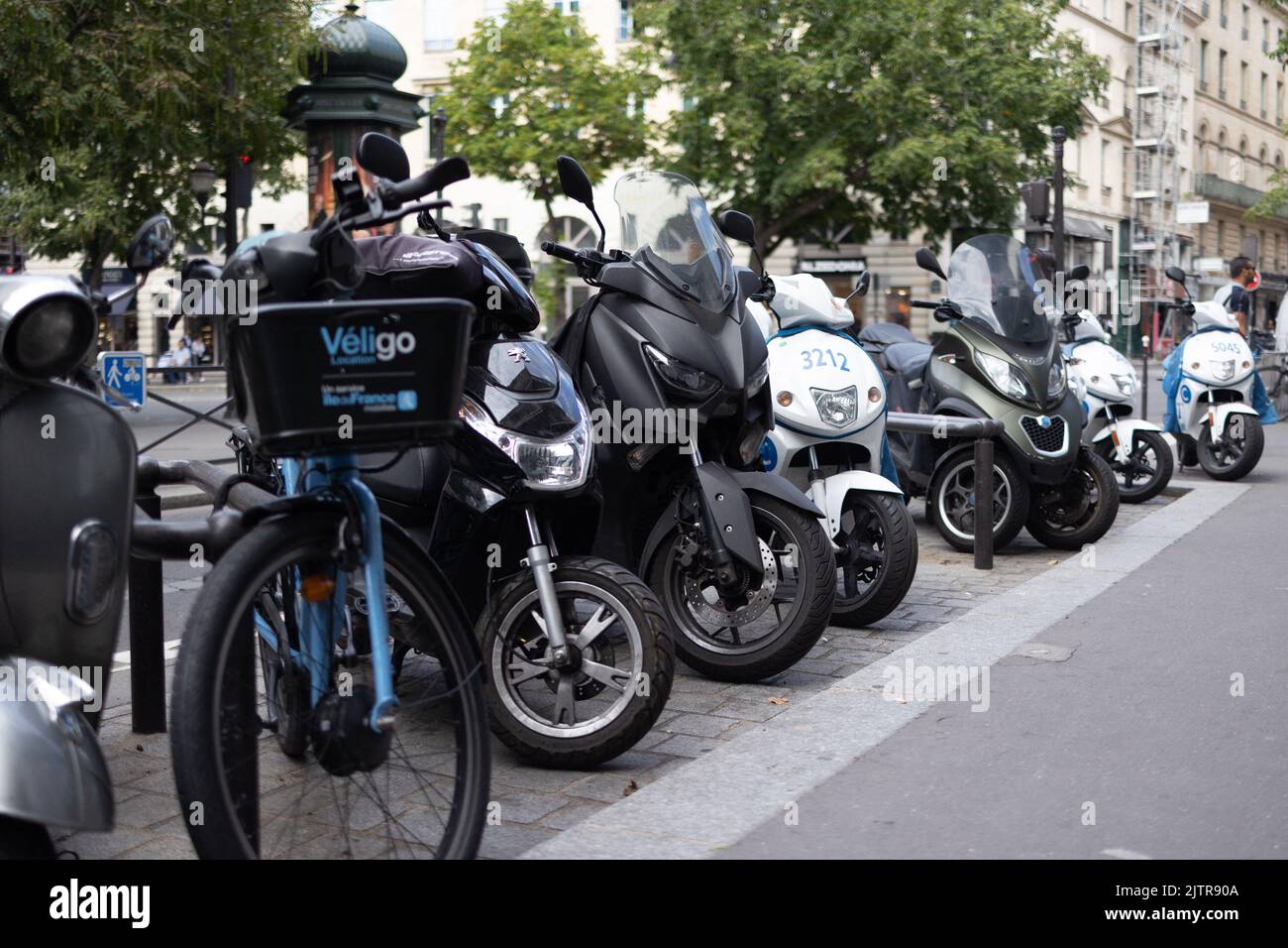 Scooters and motorbikes are seen on parking spaces in a street in Paris