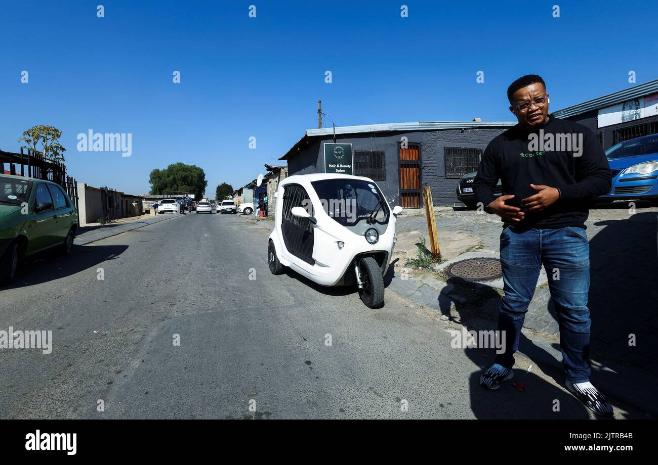 Fezile Dhlamini, founder of a business called Green Scooter, stands in front his three-wheel electric scooter during an interview with Reuters at the Alexandra township, Johannesburg, South Africa, June 7, 2022. Picture taken June 7, 2022. REUTERS/Siphiwe Sibeko Stock Photo