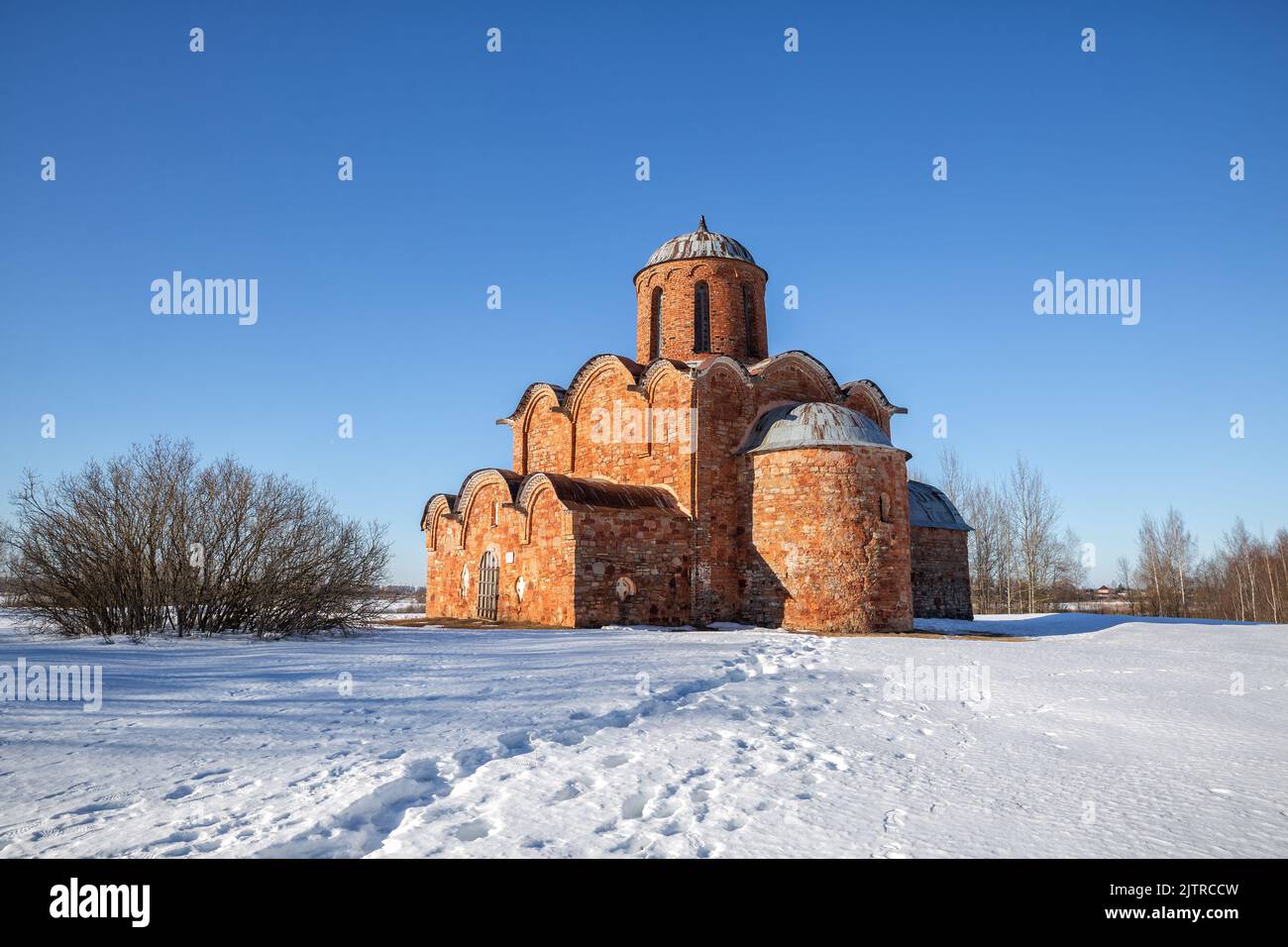 Church of the Transfiguration on Kovalevo in Veliky Novgorod vicinity, Russia. Winter countryside landscape with ancient orthodox temple made of red b Stock Photo
