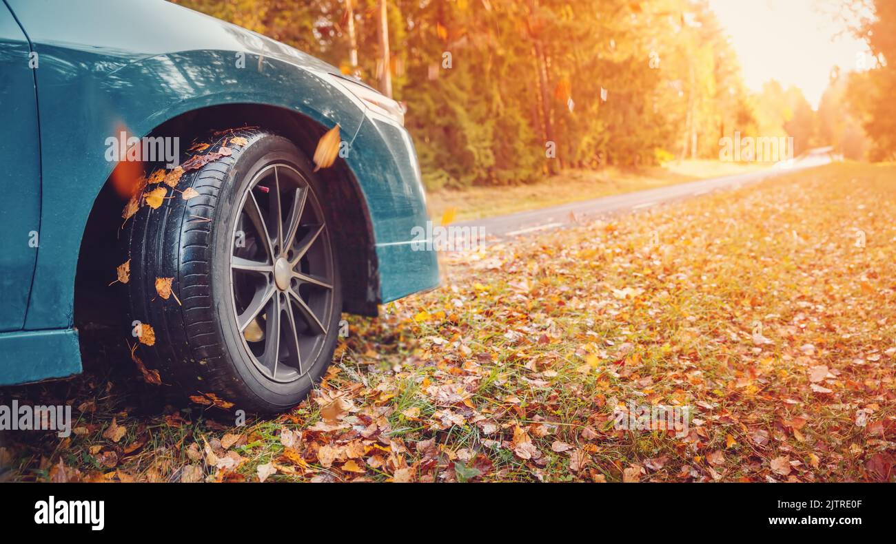 Blue car on the autumnal asphalt road in countryside Stock Photo