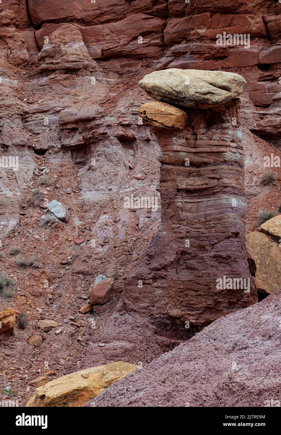 A sandstone spire has a capstone on it created by uneven erosion and