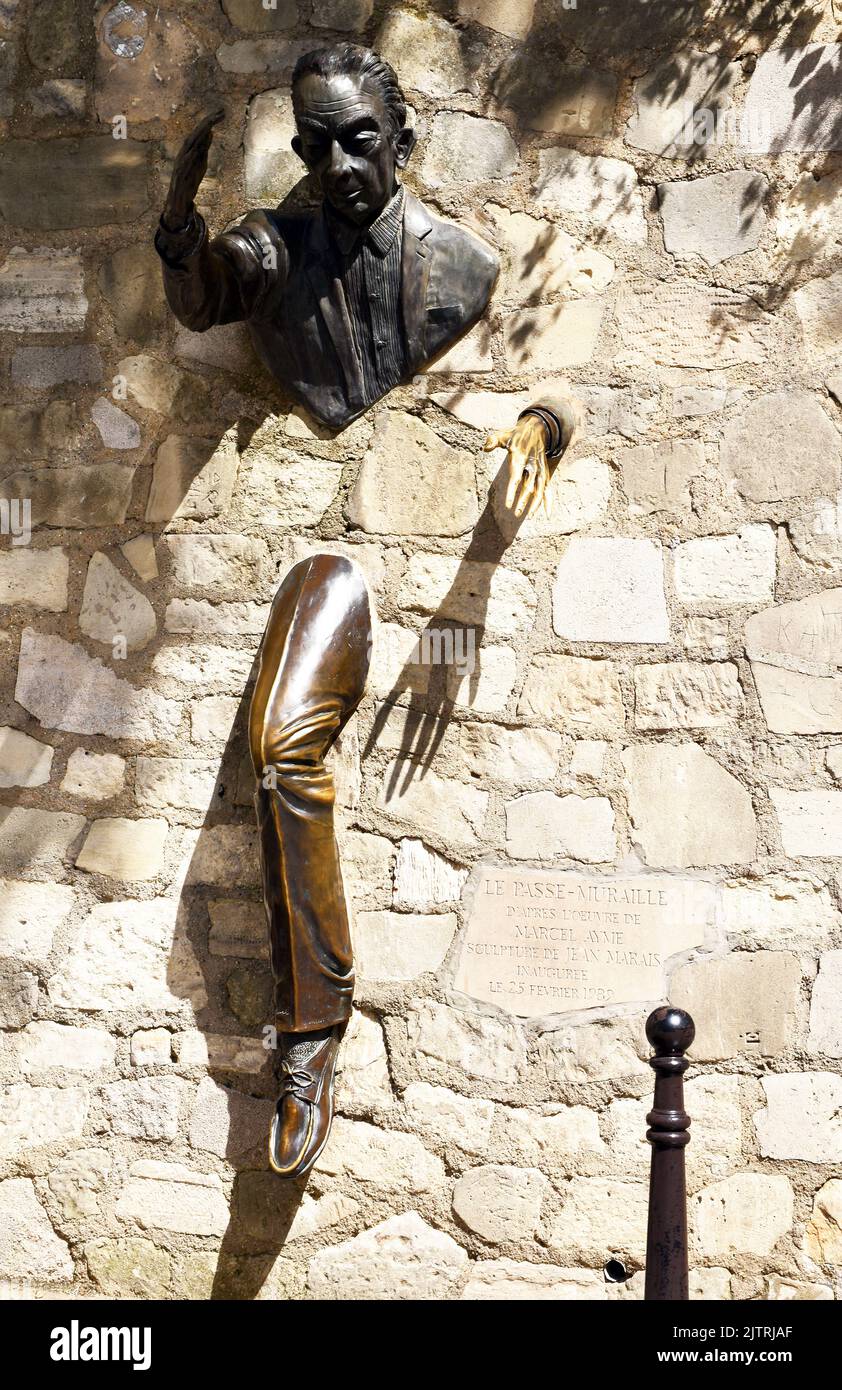 Bronze sculpture of a man apparently walking through a stone wall, an homage to the author Marcel Aymé, who wrote a short story called Le Passe Murail Stock Photo