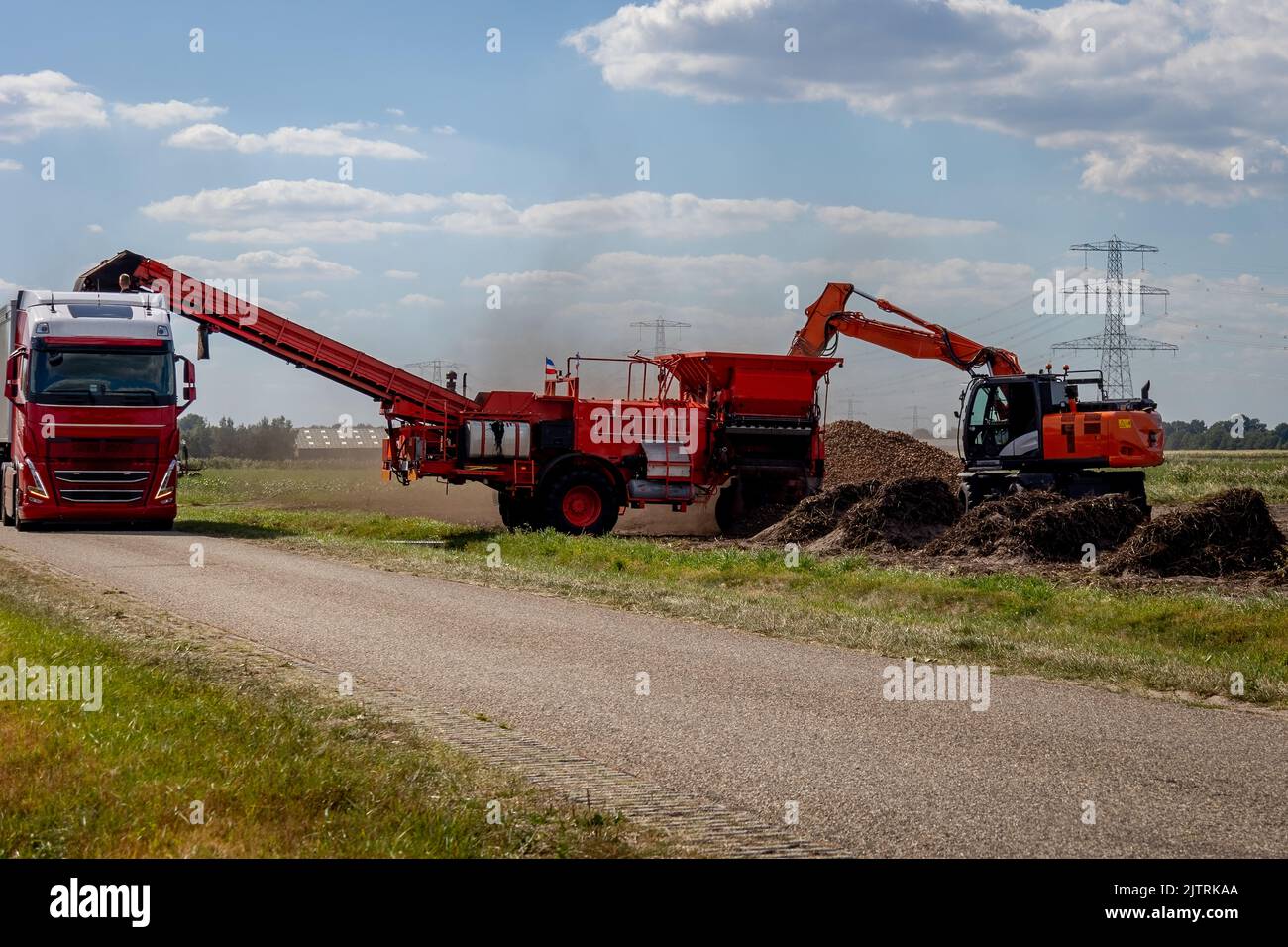 The harvest of potatoes, loaded with a crane in a potato cleaning machine that removes sand and weeds before it is deposited in the truck Stock Photo