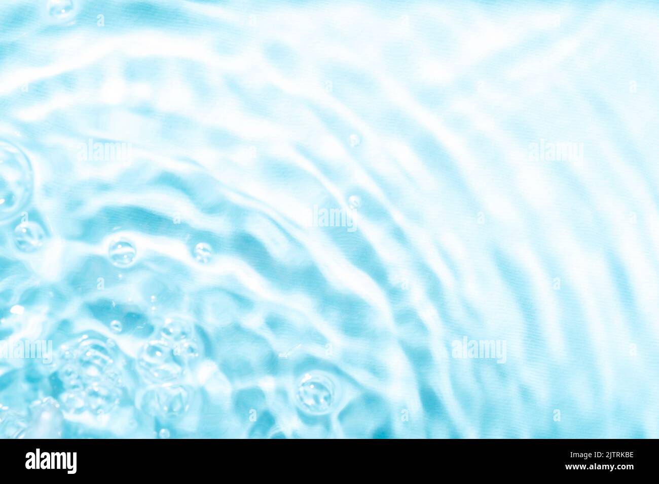 Defocused blurred ripples in blue water. Texture, background. Stock Photo