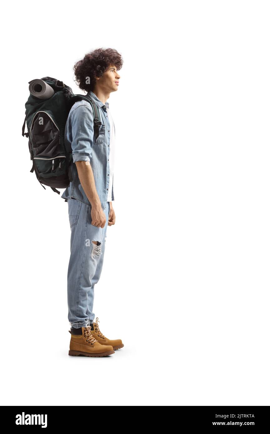 Full length profile of a young male backpacker standing isolated on white background Stock Photo