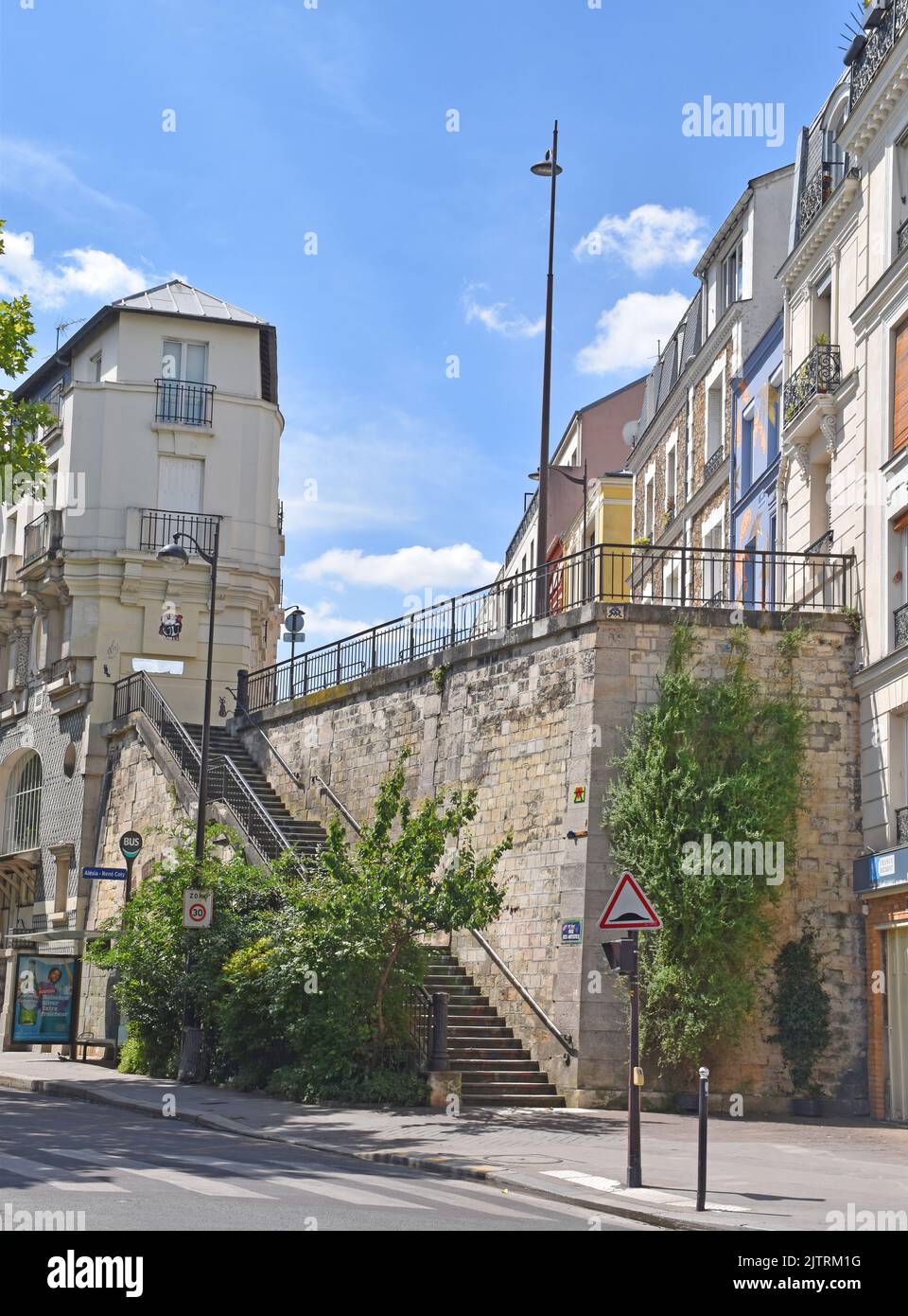 A wide stone staircase linking  r. des Artistes & r.Yves Coty in Paris, with massive retaining walls supporting the side and end of the street. Stock Photo