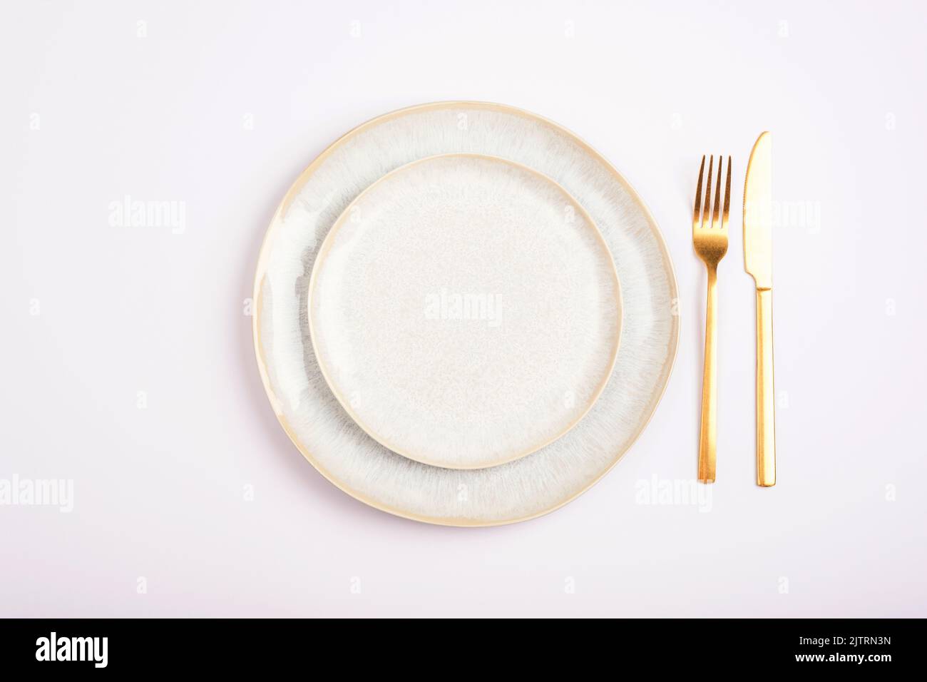 Empty plate with fork and knife on white background. Table setting. Top ...
