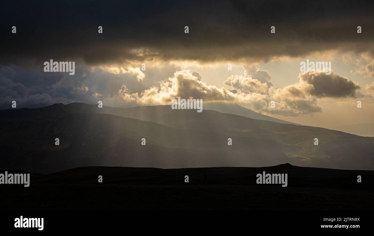 Beautiful ray of sunlight breaking through clouds at sunset Stock Photo ...
